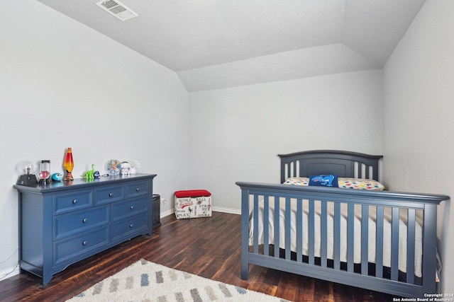 bedroom featuring dark hardwood / wood-style flooring and lofted ceiling