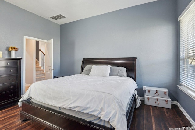 bedroom with dark hardwood / wood-style flooring