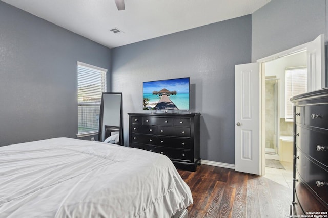 bedroom featuring ensuite bath, ceiling fan, and dark wood-type flooring