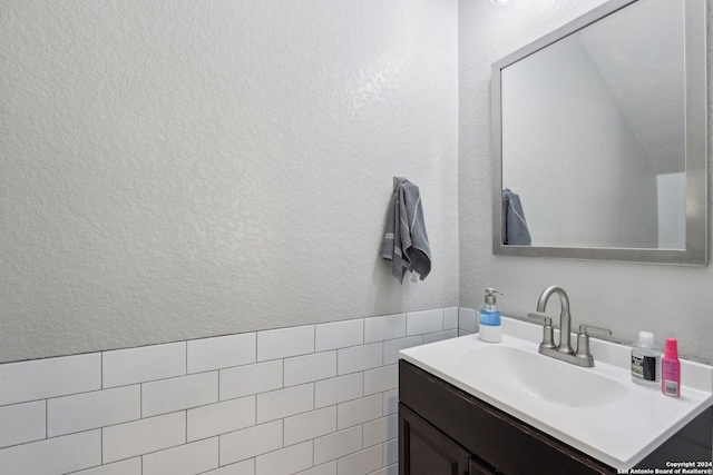 bathroom with vanity and tile walls