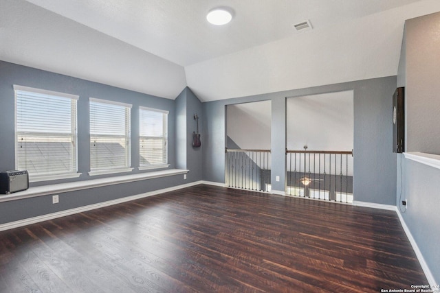 spare room with dark hardwood / wood-style floors and vaulted ceiling