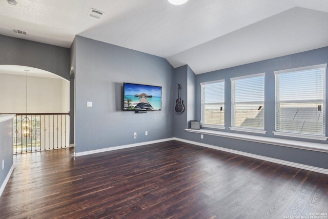 unfurnished room with dark hardwood / wood-style flooring, lofted ceiling, and an inviting chandelier