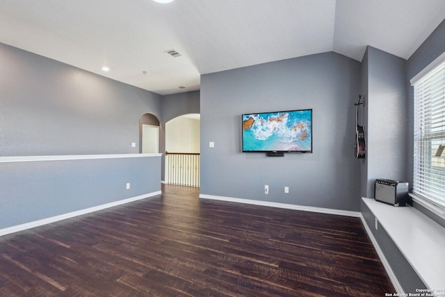 empty room featuring dark hardwood / wood-style flooring, a wealth of natural light, and lofted ceiling