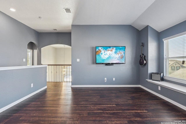 empty room featuring lofted ceiling and dark wood-type flooring