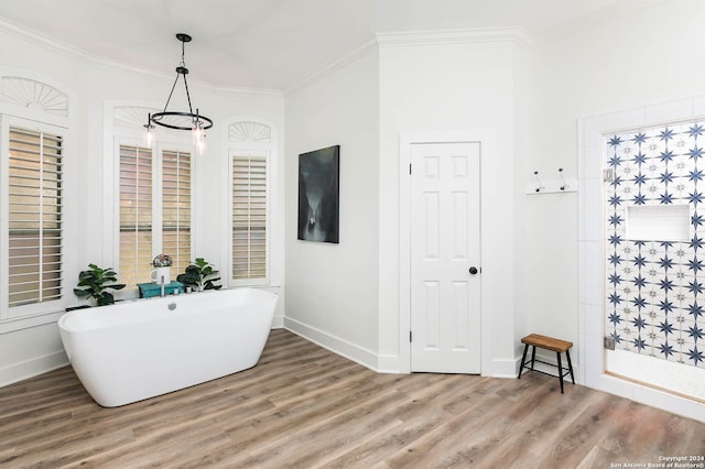 bathroom featuring a chandelier, wood-type flooring, crown molding, and a bathing tub