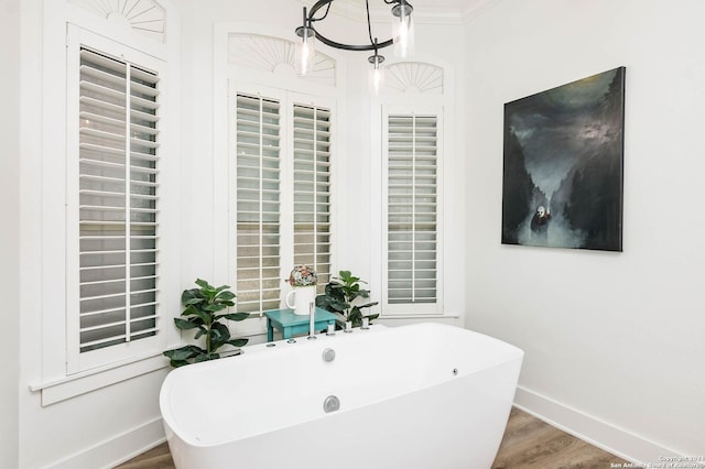 bathroom with wood-type flooring, a tub to relax in, and crown molding