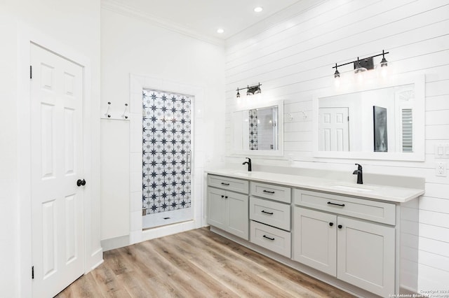 bathroom with a tile shower, crown molding, hardwood / wood-style floors, and vanity