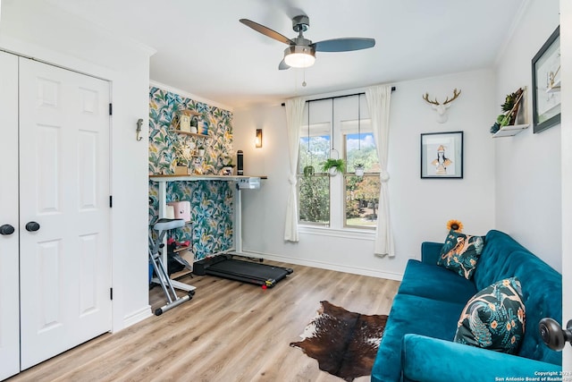 exercise area with ceiling fan, wood-type flooring, and crown molding