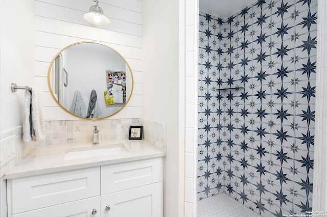 bathroom featuring a tile shower, vanity, and tasteful backsplash