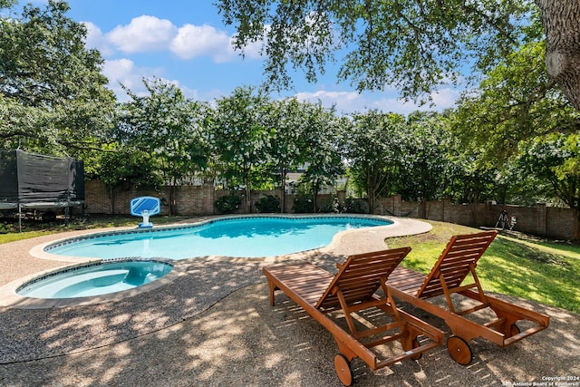 view of pool with an in ground hot tub and a trampoline