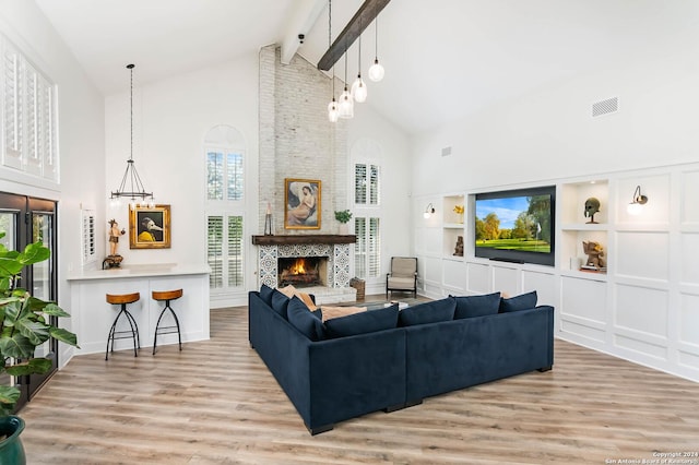 living room featuring a fireplace, high vaulted ceiling, and beamed ceiling