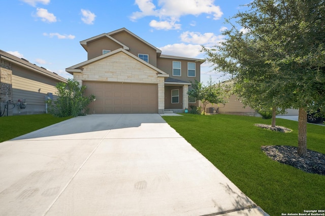 view of front of home featuring cooling unit, a front yard, and a garage