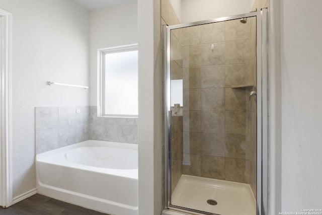 bathroom with shower with separate bathtub and hardwood / wood-style flooring