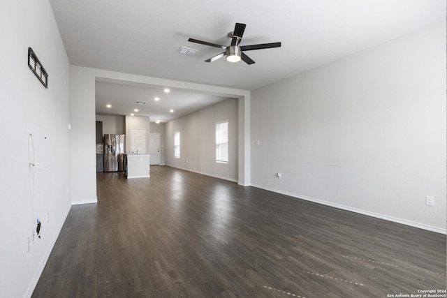 unfurnished living room with dark hardwood / wood-style flooring and ceiling fan