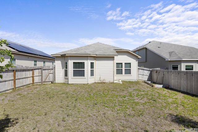 rear view of house featuring a lawn