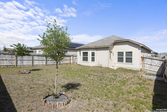 rear view of property with a yard