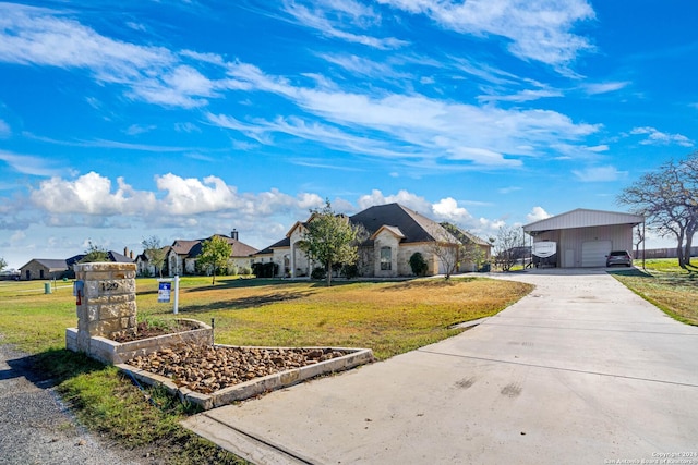 ranch-style house featuring a front yard, a garage, and an outdoor structure