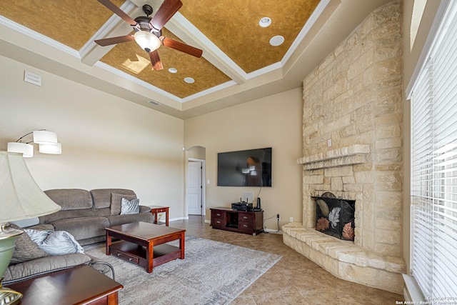 tiled living room with a towering ceiling, ornamental molding, coffered ceiling, ceiling fan, and a fireplace