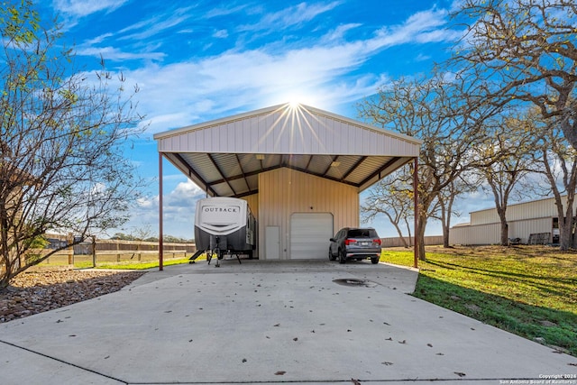 view of outbuilding with a carport, a garage, and a yard