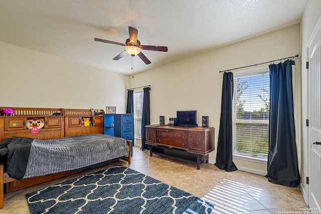 tiled bedroom with a textured ceiling and ceiling fan