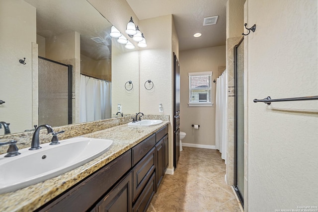 bathroom featuring a tile shower, vanity, and toilet