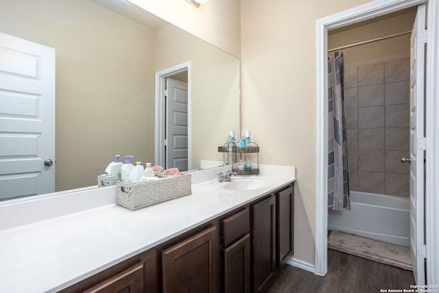 bathroom with shower / bath combo with shower curtain, wood-type flooring, and vanity