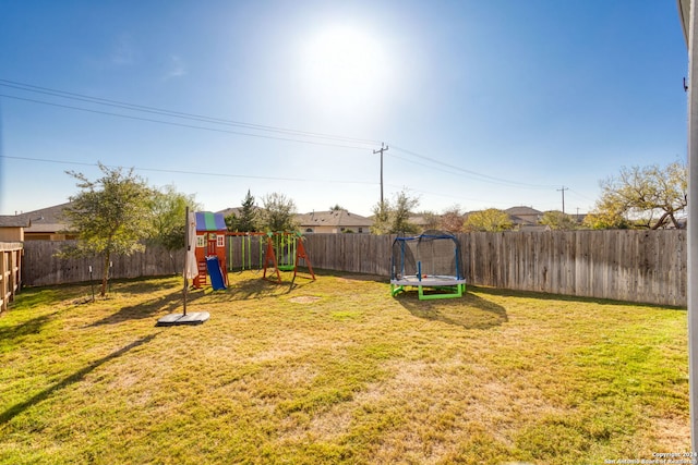 view of yard featuring a playground and a trampoline