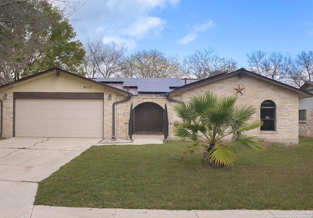 view of front of property featuring a front yard, solar panels, and a garage