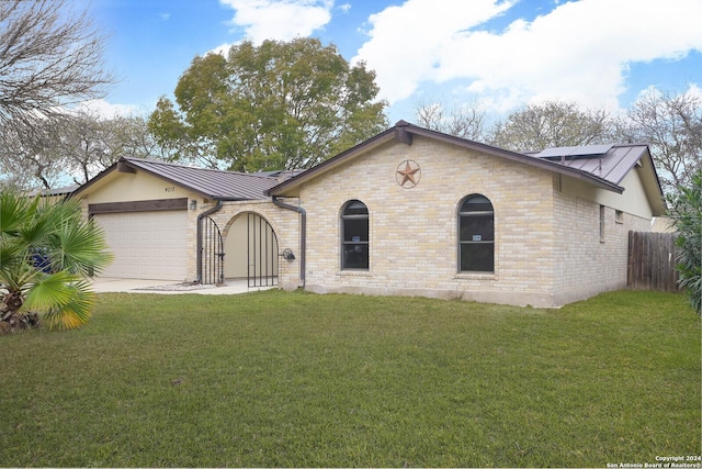 ranch-style house featuring solar panels, a garage, and a front lawn