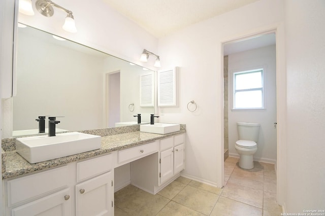 bathroom featuring tile patterned flooring, vanity, and toilet