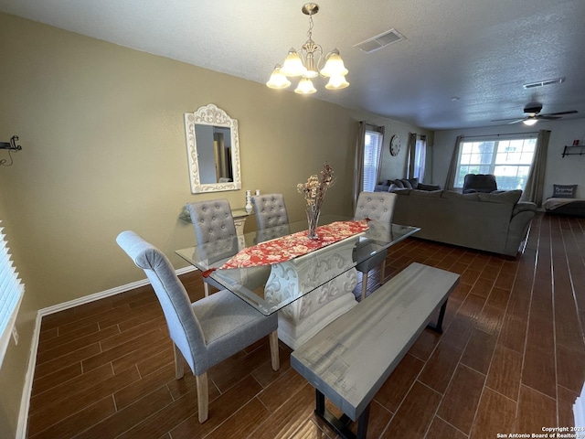 dining room featuring ceiling fan with notable chandelier and a textured ceiling