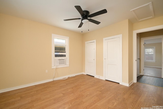 unfurnished bedroom featuring ceiling fan, light hardwood / wood-style flooring, and cooling unit