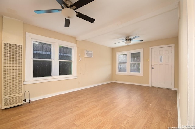 unfurnished room with a wall mounted AC, ceiling fan, and light hardwood / wood-style flooring