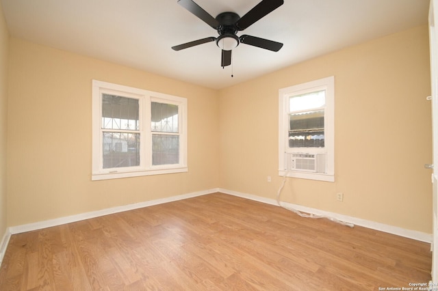 spare room with light wood-type flooring, cooling unit, and ceiling fan