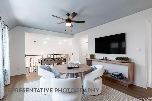 dining room with ceiling fan, hardwood / wood-style floors, and vaulted ceiling