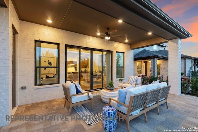 patio terrace at dusk with outdoor lounge area and ceiling fan