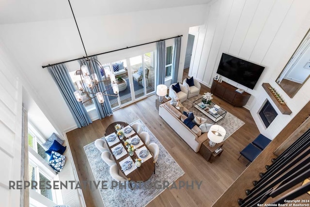 living room featuring light hardwood / wood-style flooring, high vaulted ceiling, and a chandelier