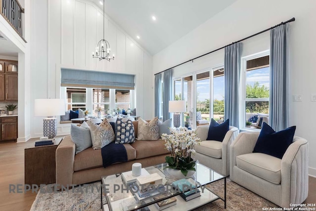 living room with high vaulted ceiling, light wood-type flooring, and a notable chandelier