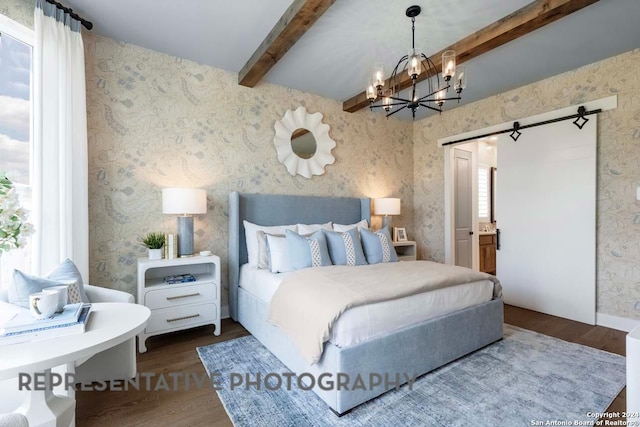 bedroom with beam ceiling, ensuite bathroom, a chandelier, and wood-type flooring