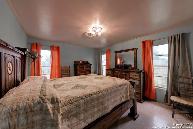 bedroom featuring multiple windows and crown molding