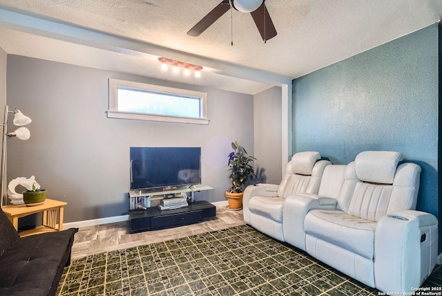 living room featuring a textured ceiling and ceiling fan