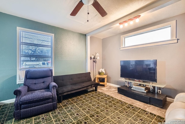 living room featuring a textured ceiling and ceiling fan