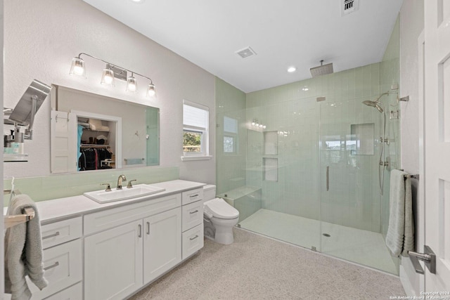 bathroom featuring vanity, toilet, and a shower with shower door