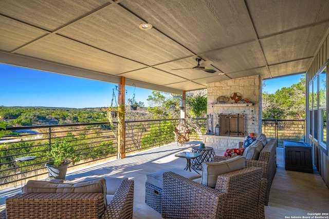 view of patio with an outdoor living space with a fireplace and ceiling fan