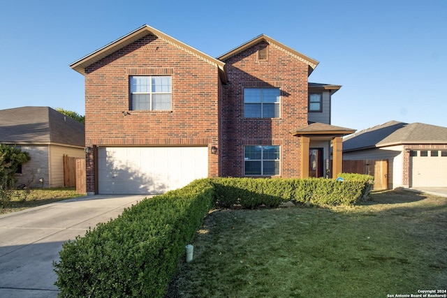 view of property featuring a garage and a front lawn