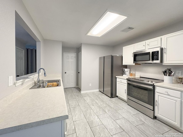 kitchen featuring white cabinets, stainless steel appliances, and sink