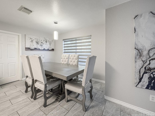 dining space featuring a textured ceiling