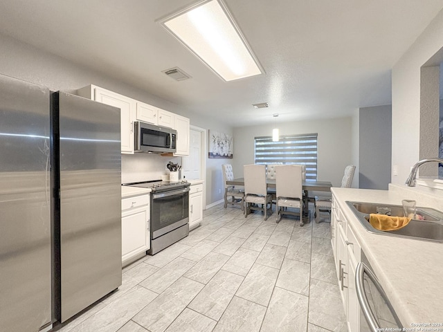 kitchen featuring sink, white cabinets, and appliances with stainless steel finishes