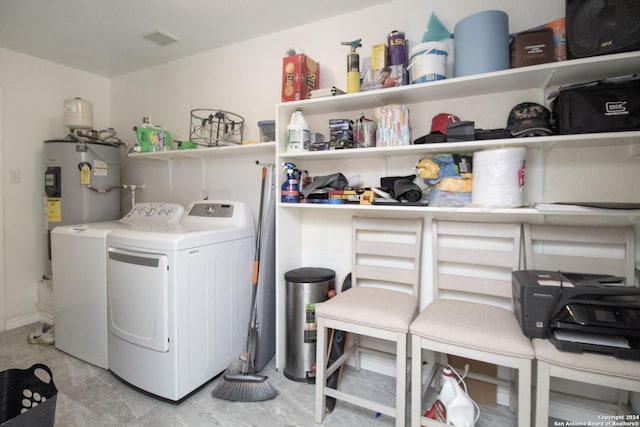 laundry area with electric water heater and washer and clothes dryer