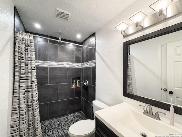 bathroom with a shower with shower curtain, vanity, a textured ceiling, and toilet